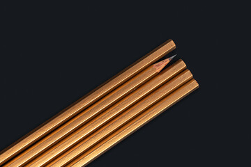 One sharpened pencil standing out from the blunt ones. One not like other. Leader concept. Template with copy space by top view closeup macro photo of wooden golden pencil poster mock-up