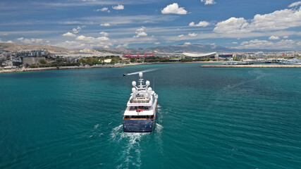 Aerial drone photo of luxury yacht cruising near beautiful round port of Mikrolimano or small port in the heart of Piraeus, Attica, Greece