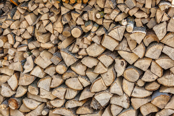 Background of hewed smooth wooden logs. Cut wood texture. Pile of chopped fire wood prepared for winter
