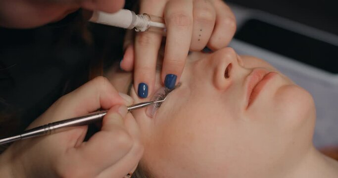 Lashmaker does the eyelash lamination procedure for the client in the beauty salon, cosmetic services, beauty care procedures, 4k 60p Prores HQ