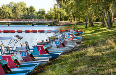 Fototapeta na wymiar Catamarans on the bank of the river on summer bright day.