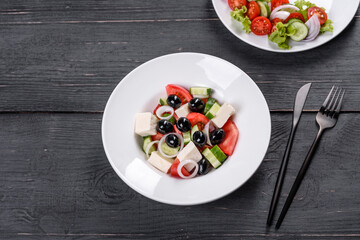 Fresh delicious Greek salad with tomato, cucumber, onions and olives with olive oil