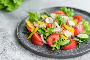 Fresh delicious salad with chicken, tomato, cucumber, onions and greens with olive oil