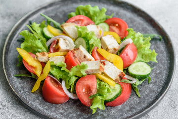 Fresh delicious salad with chicken, tomato, cucumber, onions and greens with olive oil