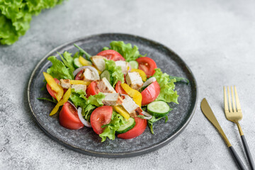 Fresh delicious salad with chicken, tomato, cucumber, onions and greens with olive oil