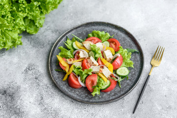 Fresh delicious salad with chicken, tomato, cucumber, onions and greens with olive oil