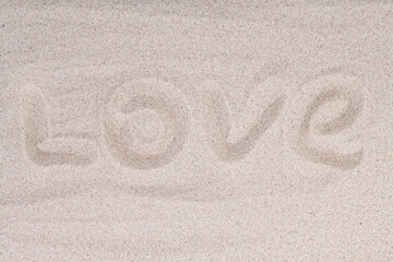 Fototapeta na wymiar Inscription Love on the sand at the beach. Love written in the sand on beach with wave. Concepts photography. Selective focus
