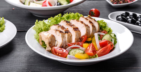 Fresh delicious salad with chicken, tomato, cucumber, onions and greens with olive oil