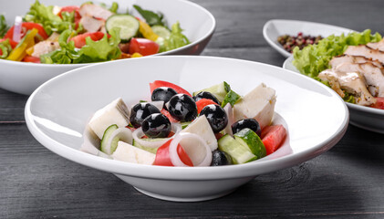 Fresh delicious Greek salad with tomato, cucumber, onions and olives with olive oil