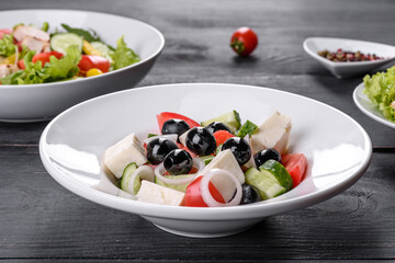Fresh delicious Greek salad with tomato, cucumber, onions and olives with olive oil