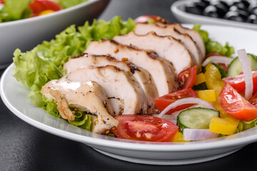 Fresh delicious salad with chicken, tomato, cucumber, onions and greens with olive oil
