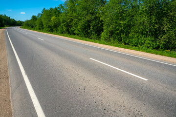 Asphalt country road. Road markings. Summer sunny day.