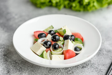 Fresh delicious Greek salad with tomato, cucumber, onions and olives with olive oil