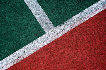 floor covering on a soccer field red green with white lines close-up. stadium