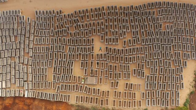 Man in the center of open empty graves, aerial view
drone view pull up shot revealing dozens of open emty tombs 
