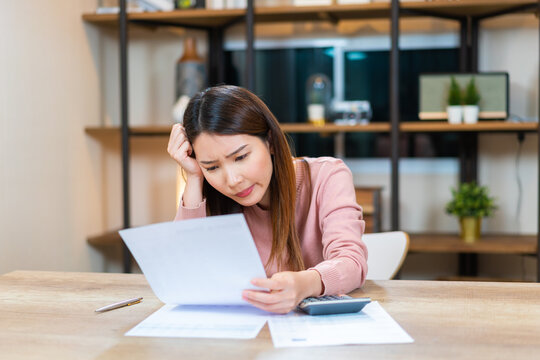 frustrated Asian woman looking at the paper bills upset throwing crumpled paper away. mental problems, failure reaction