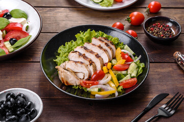 Fresh delicious salad with chicken, tomato, cucumber, onions and greens with olive oil
