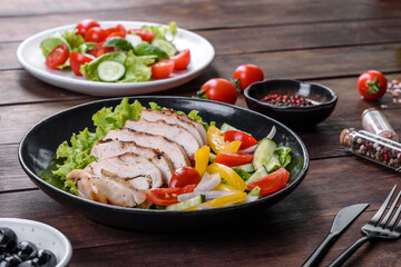 Fresh delicious salad with chicken, tomato, cucumber, onions and greens with olive oil
