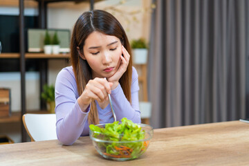 Asian woman bored to eat vegetable salad want to quit vegetarian