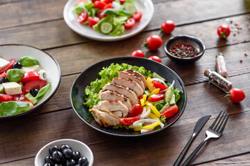 Fresh delicious salad with chicken, tomato, cucumber, onions and greens with olive oil