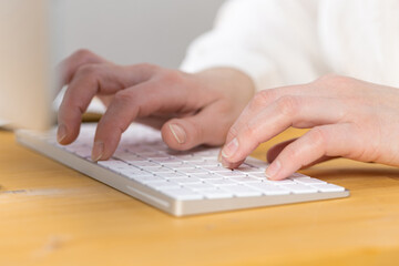 Woman office worker typing on white keyboard