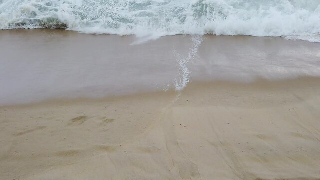 Vague recouvrant le sable du bord de plage en slow-motion
