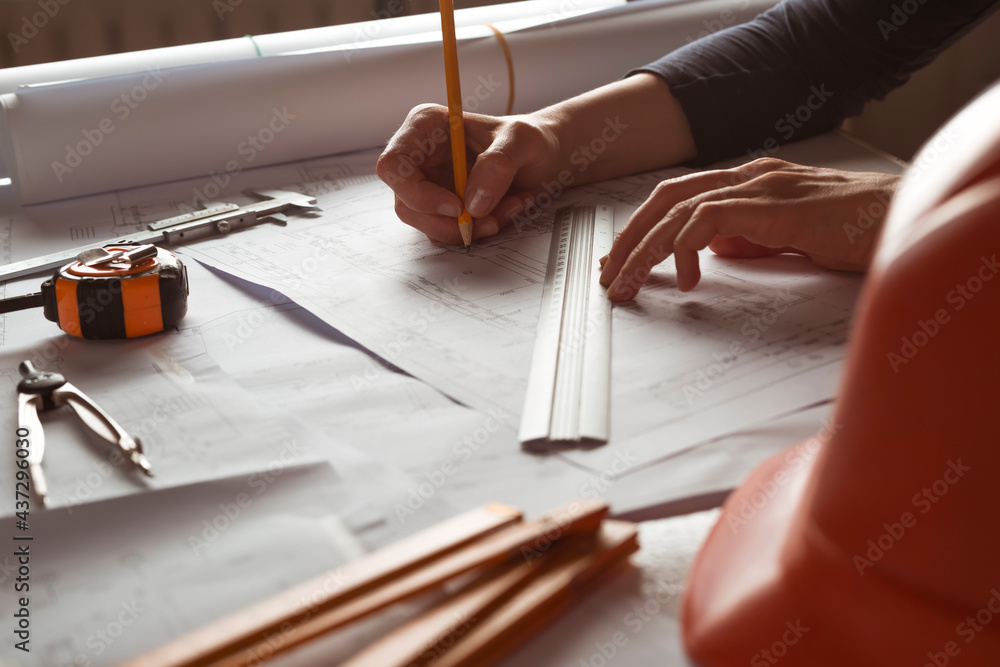 Poster the hands of a professional architect draw a sketch of a design project with a pencil. work table of