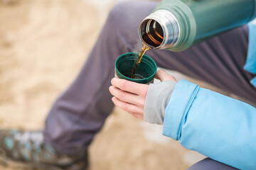 person with  a thermos in winter seaside