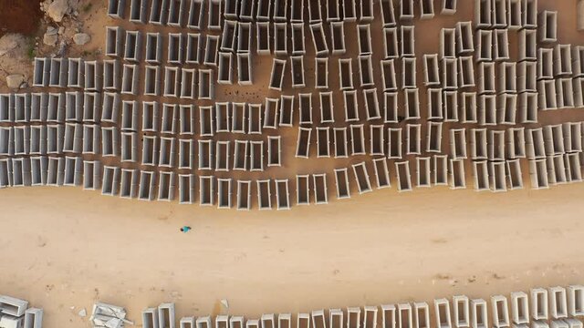 Man walking close to many empty graves, aerial view
drone view over dozens of open emty tombs 

