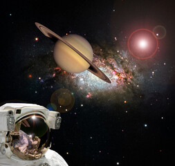 Naklejka na ściany i meble Astronaut and Saturn. Fascinating dark space. The elements of this image furnished by NASA.