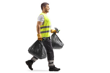 Full length profile shot of a waste collector in a uniform and gloves carrying bin bags