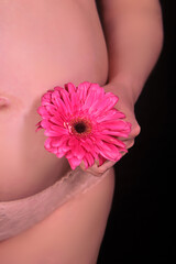 Woman with red gerbera flower, pregnancy and spring tenderness