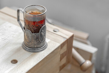 Glass of hot tea in an old silver cup holder on a wooden table