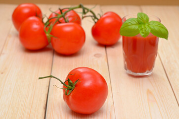 vegetable tomato and a glass of tomato juice in the background