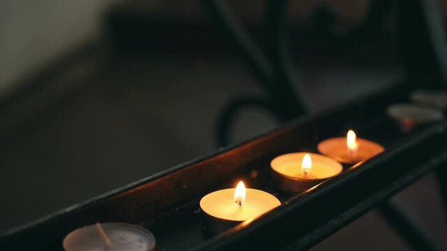 Religious Caucasian Female Lighting Up a Paraffine Wax Prayer Candle and Putting in On a Stand in Church