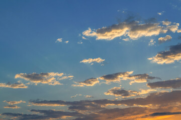 Summer evening sky in the picturesque clouds, lit by the rays of the setting sun.