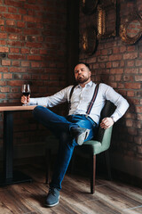 Handsome young man enjoying a glass of red wine