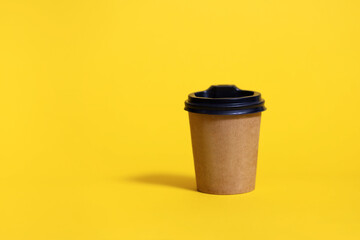 Disposable coffee cup for cafe on yellow background. Development of corporate identity for a restaurant or bar. Brown cardboard coffee cup mockup. Disposable Plastic and Paper Hot Drinks Template