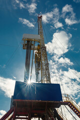 Drilling rig for drilling wells for oil and gas. General detailed view. View from the side from bottom to top. Drill tower on the base and drill pipes for lowering into the well