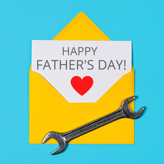 Happy father's day banner. Yellow Envelope and wrench on blue background
