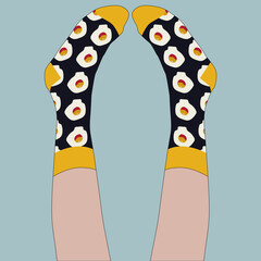 They wear socks with a print of scrambled eggs on their feet. The girl lies with her legs raised and looks at her socks. Black socks, blue background