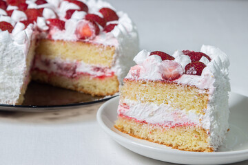 Creamy strawberry cake. Homemade cake with whipped cream and fresh strawberries. Cut piece of cake