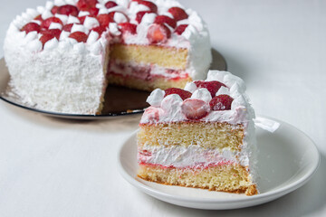 Creamy strawberry cake. Homemade cake with whipped cream and fresh strawberries. Cut piece of cake