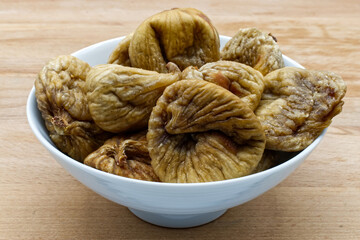 Dried figs fruit in a bowl on wooden table. Healthy eating and proper lifestyle.