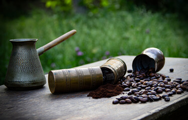Manual coffee grinder for grinding coffee beans with coffee bean and ground coffee on wooden background