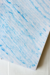 patterned background in cobalt blue watercolor - applied randomly with the flat side of a bristle paint brush on standard sketchbook paper in rows - photo top-down or flat lay style with free s