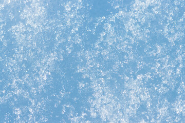 Beautiful winter background with snowy ground. Natural snow texture. Wind sculpted patterns on snow surface.