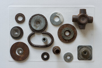 metallic objects purposefully arranged on old white art paper - photographed from above in a flat...