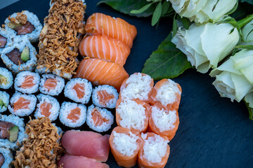 sushi and rolls laid out on a plate of ardesia