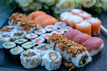 sushi and rolls laid out on a plate of ardesia